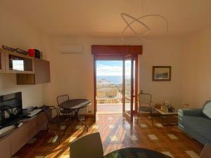 ein Wohnzimmer mit einer Couch und einem Tisch und Stühlen in der Unterkunft Bellavista Gallipoli - Casa del Sole con box auto in Gallipoli