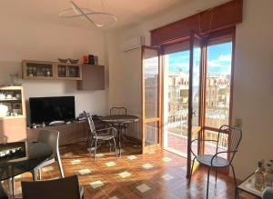 ein Wohnzimmer mit Tisch und Stühlen und einem Fenster in der Unterkunft Bellavista Gallipoli - Casa del Sole con box auto in Gallipoli