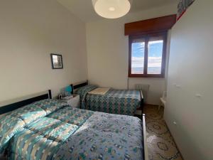 ein Schlafzimmer mit zwei Betten und einem Fenster in der Unterkunft Bellavista Gallipoli - Casa del Sole con box auto in Gallipoli