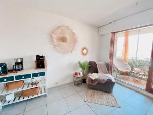 un soggiorno con una sedia e una finestra di Appartement Coup de Coeur avec Parking et Piscine - 131 a Canet-en-Roussillon Altre 14 foto