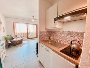 una cucina con un lavello e un piano di lavoro di Appartement Coup de Coeur avec Parking et Piscine - 131 a Canet-en-Roussillon