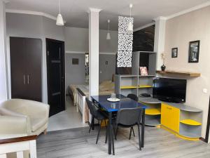 a living room with a dining room table and a bedroom at Hotel Domashnii in Zhytomyr