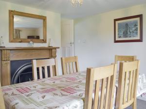 - une chambre avec une table, des chaises et une cheminée dans l'établissement Rose Farm Cottage, à Frostenden