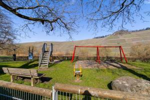 a park with a swing set and a bench at Fewomo, Mosel Maisonette, mit Terrasse & Winzerflairallee, für 6 Perfekt, für 8 geeignet in Brauneberg
