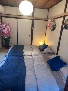 横浜市にあるMaharaniのベッドルーム1室(大型ベッド1台、青いシーツ付)