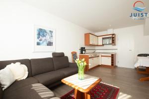 a living room with a couch and a table at Haus Insa 144 - Ferienwohnung 4 in Juist