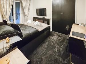 a hotel room with a bed and a television at Newfold Cottage in Bowness-on-Windermere