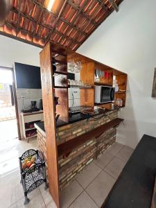 a kitchen with a counter with a microwave at Casa Florida in Beberibe +11 photos