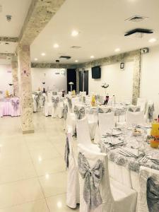 a banquet hall with white tables and white chairs at Pensiune Matrix in Curtea de Argeş