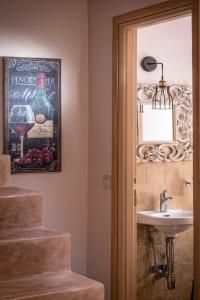 un baño con lavabo y una foto de una botella de vino en Phaistos Villas - Private Pool Luxury Retreats, en Sívas