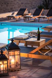 una mesa de picnic con copas de vino y luces junto a una piscina en Phaistos Villas - Private Pool Luxury Retreats, en Sívas