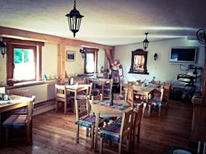 een vrouw in een restaurant met tafels en stoelen bij Penzión Mlynárka in Rajecké Teplice