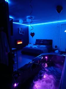a room with a tub with purple lights in it at Un moment pour nous EI in Bruay-sur-lʼEscaut +7 photos