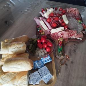 a table topped with a tray of meats and cheese at Un moment pour nous EI in Bruay-sur-lʼEscaut