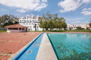 einem Pool vor einem großen weißen Gebäude in der Unterkunft Magnificent Beach Apartment in Vale de Pedras