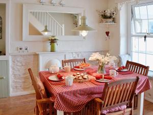 a dining room table with a red and white checked table cloth at Seaside Stories in Brixham