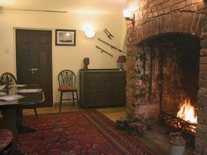 a living room with a brick fireplace and a table at Churchview House in Winterborne Abbas +20 photos