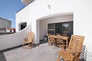 eine Terrasse mit Stühlen und einem Tisch auf einem Balkon in der Unterkunft Magnificent Beach Apartment in Vale de Pedras