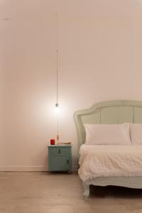 a bedroom with a bed and a table with a lamp at Casa da Peça Lodge in Ponta Delgada