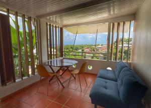 un salon avec une table et un canapé bleu dans l'établissement Appartement vue mer, à La Trinité
