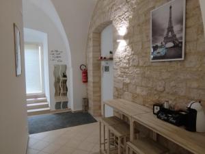 a room with a stone wall and tables and a refrigerator at Dimora Nonno Mimì in Bitetto