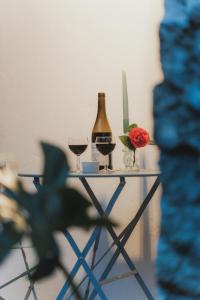 a table with two glasses and a bottle of wine at Casa da Peça Lodge in Ponta Delgada