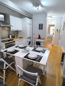 eine Küche mit einer weißen Insel mit Tellern drauf in der Unterkunft El Piso de Montse in A Coruña