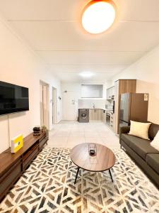 a living room with a couch and a table at Nala Realty at The Aura 327 in Northriding +16 photos