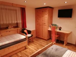 a bedroom with a bed and a desk and a table at Hänsler's Hof in Arzl im Pitztal