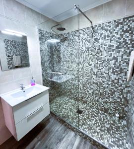 y baño con ducha, lavamanos y ducha. en Vista Reis Magos, en Caniço