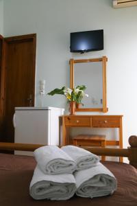 a bedroom with a bed with towels on it at Panorama Rooms in Pyrgos Dirou