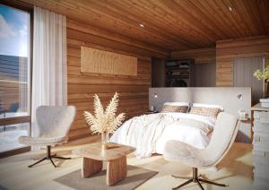 a bedroom with a bed and two chairs and a table at Wilderness Hotel Saariselkä in Saariselka +36 photos