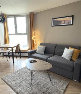 a living room with a couch and a table at Vivez Le Havre ! Studio en Résidence bord de mer - Port de plaisance - 3 Etoiles in Le Havre