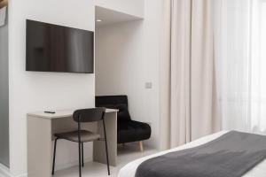 a bedroom with a desk and a chair and a television at Iodis Relais in Naples