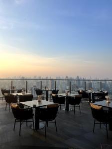 a view from the roof of a restaurant with tables and chairs at Sky Residence in Ekkamai in Bangkok