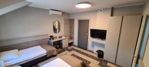 a hotel room with a bed and a television at Pokoje Gościnne Gum-Bar in Biskupice