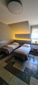 two beds in a room with a ceiling at Pokoje Gościnne Gum-Bar in Biskupice