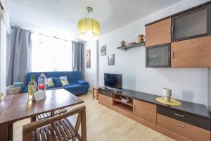 een woonkamer met een blauwe bank en een tv bij Complejo Andalucía Torrecilla Beach in Nerja