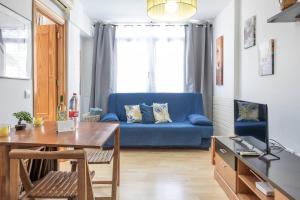 een woonkamer met een blauwe bank en een tafel bij Complejo Andalucía Torrecilla Beach in Nerja