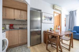 een keuken met een tafel en een roestvrijstalen koelkast bij Complejo Andalucía Torrecilla Beach in Nerja +14 foto's