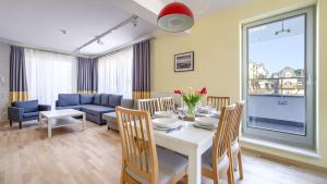 Un comedor y una sala de estar con mesa y sillas. en Casa Marina Komfort, Sun & Snow, en Świnoujście