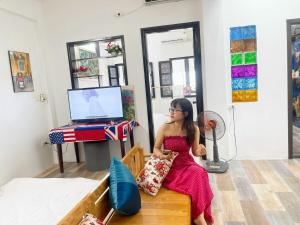 una ragazza seduta su una panchina in una stanza di Bumbo Apartment a Hanoi