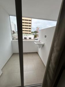 Un baño con lavabo y una gran ventana. en HOUSE AND SUITE SF RIVADAVIA, en Santa Fe