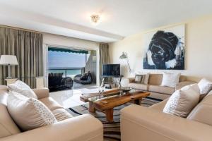 a living room with a couch and a table at Dolphin Beach Penthouse in Cape Town