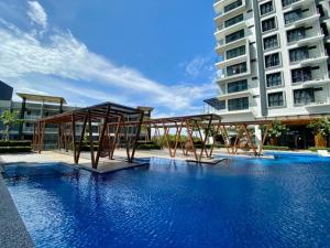 a swimming pool with benches in front of a building at K AVENUE B09 STUDIO king BED in Donggongon