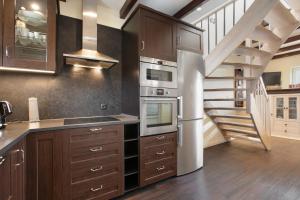 a kitchen with wooden cabinets and a spiral staircase at Ferienhaus Martje in Hennstedt