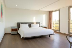 a bedroom with a large white bed and a window at Atelier Loft Oliver Palm Resort in Marrakesh