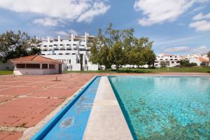 a swimming pool in front of a white building at Lovely And New Apartment In Oura in Albufeira
