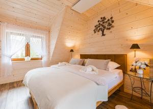 a bedroom with a large white bed in a wooden room at Słoneczna Wetlina Dom in Wetlina