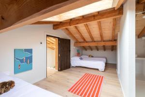 a bedroom with two beds and a red rug at Villa des Résiniers, proche plage & forêt, wifi in Moliets-et-Maa +37 photos